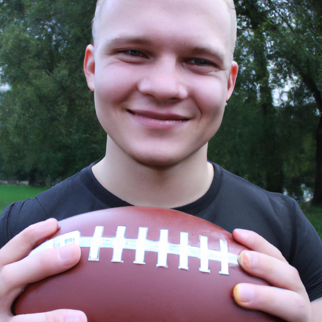 Man holding a football, smiling